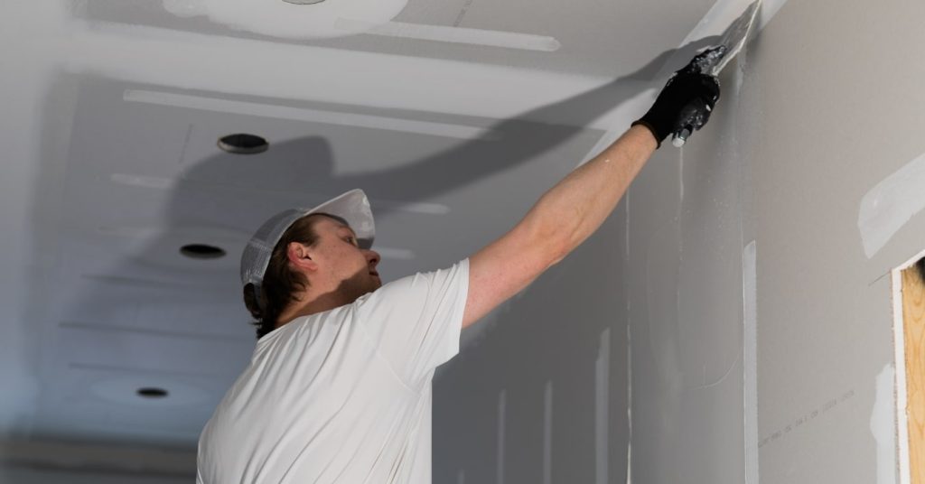 Worker installing drywall